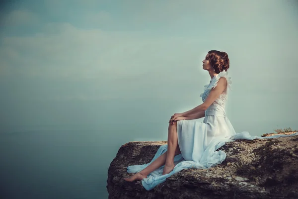 Bella sposa in posa sulla costa con abito angelico — Foto Stock