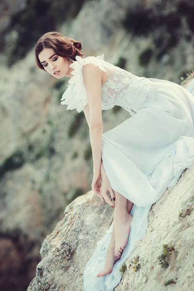 Schöne Braut posiert an der Küste mit Engelskleid — Stockfoto