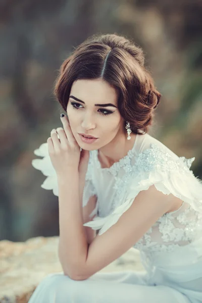 Beautiful bride posing on the coast with angelic dress — Stock Photo, Image