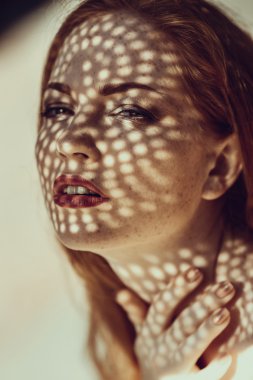 Portrait of a charming young woman outdoor. Light and shadow.