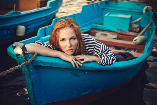 Hermosa sexy mujer es vestida en un mar despojado chaleco se sienta en la orilla del mar sueños . — Foto de Stock