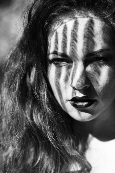 Portrait of a charming young woman outdoor. Light and shadow. — Stok fotoğraf