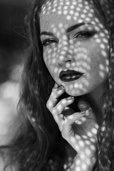 Portrait of a charming young woman outdoor. Light and shadow. — Stok fotoğraf