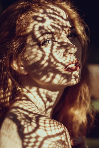 Portrait of a charming young woman outdoor. Light and shadow. — ストック写真