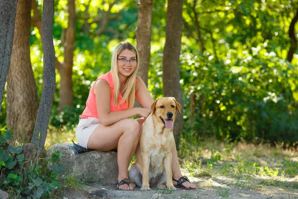 아름 다운 젊은 여자와 그녀의 강아지 래브라도 리트리버 여름에 야외의 아름 다운 공원 — 스톡 사진