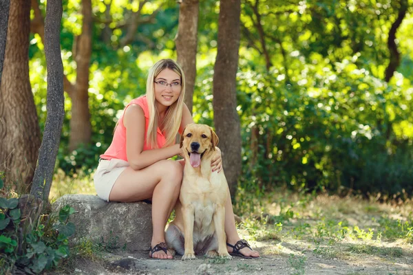 아름 다운 젊은 여자와 그녀의 강아지 래브라도 리트리버 여름에 야외의 아름 다운 공원 — 스톡 사진