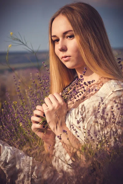 Schöne Frau aus der Provence entspannt sich im Lavendelfeld und beobachtet den Sonnenuntergang. Serie. verführerisches Mädchen mit lila Lavendel. — Stockfoto