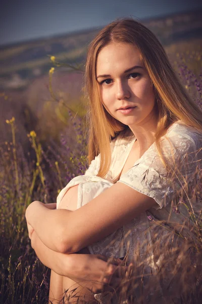 Schöne Frau aus der Provence entspannt sich im Lavendelfeld und beobachtet den Sonnenuntergang. Serie. verführerisches Mädchen mit lila Lavendel. — Stockfoto