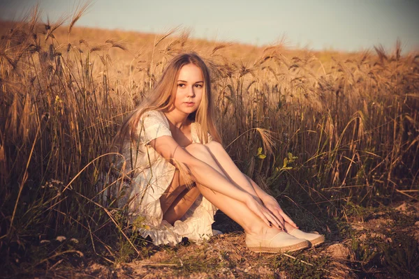 Mujer hermosa y saludable caminando al aire libre. Mujer joven seductora en el campo de trigo, mujer sensual delicada en la naturaleza. piel perfecta, pelo rizado. —  Fotos de Stock