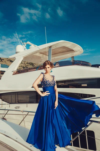 Bella ragazza sexy in un vestito e trucco, viaggio estivo su uno yacht con le vele bianche sul mare o sull'oceano — Foto Stock