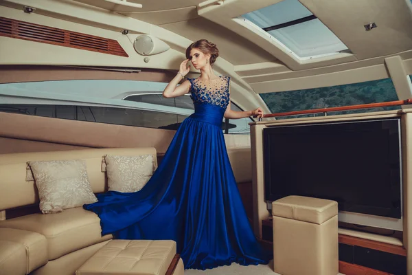 Bella ragazza sexy in un vestito e trucco, viaggio estivo su uno yacht con le vele bianche sul mare o sull'oceano — Foto Stock