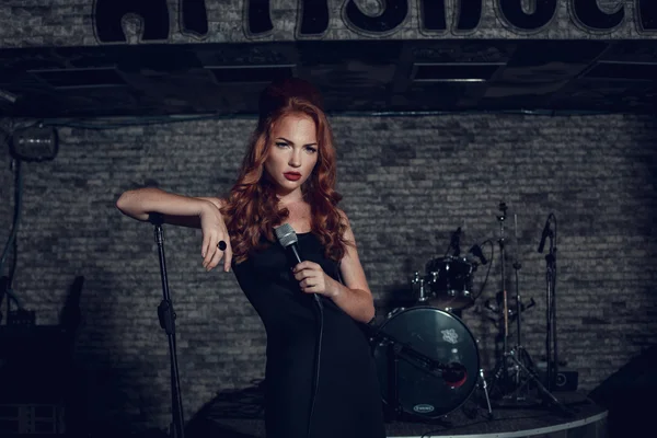 Young singer woman with red hair on the scene — Stock fotografie