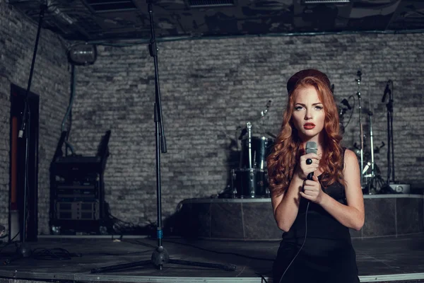 Jovem cantora com cabelo vermelho na cena — Fotografia de Stock