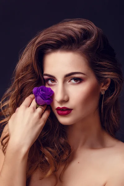 Foto estúdio de moda da bela mulher morena com maquiagem brilhante com um buquê de eustoma roxo e branco — Fotografia de Stock