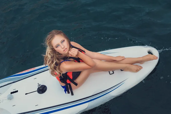 Surfer girl posing with her surfboard Stock Image