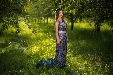 Erik bahçede uzun mavi elbiseli kızla