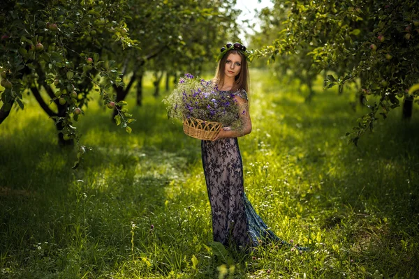 Ragazza con prugne e cesto di fiori — Foto Stock