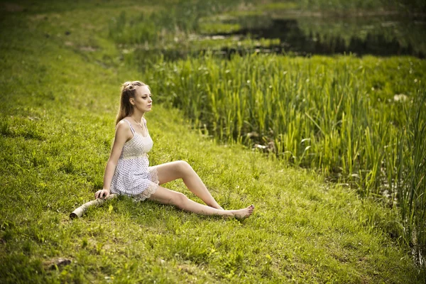 Jonge mooie blonde meisje op de aard — Stockfoto