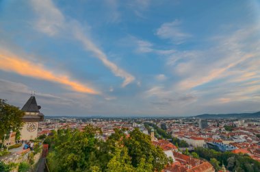 Graz, Avusturya - 30 Ağustos 2020: Graz şehri ve Schlossberg tepesindeki ünlü saat kulesi, Graz, Styria bölgesi, gün batımında