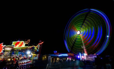 Graz, Avusturya - 05 Ekim 2019: lunaparkta dönme dolap gece hareket halindedir. Uzun pozlu fotoğrafçılık.