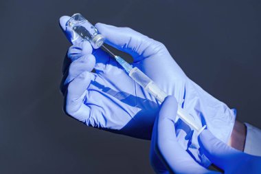 Doktor ellerinde aşı şişesi ve şırıngayla Coronavirus COVID-19 için dünya çapında toplu aşılama, grip ya da grip, dünya aşılama kavramının başlangıcı. Seçici odak