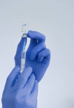 Doktor ellerinde aşı şişesi ve şırıngayla Coronavirus COVID-19 için dünya çapında toplu aşılama, grip ya da grip, dünya aşılama kavramının başlangıcı. Seçici odak