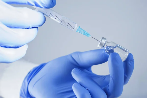 Doktor ellerinde aşı şişesi ve şırıngayla Coronavirus COVID-19 için dünya çapında toplu aşılama, grip ya da grip, dünya aşılama kavramının başlangıcı. Seçici odak