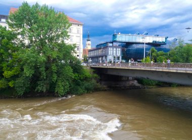 Graz, Avusturya-17.08.2020: Mur nehri, Aşk Köprüsü ve çağdaş sanat için modern sanat müzesi Kunsthaus Graz, Graz 'ın eski mimarisinin ortasında kalmış bir uzaylı gibi görünüyorlar.