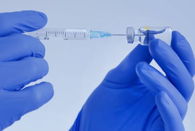 Graz, Austria-26.01.2021: Doctor hands holding a AstraZeneca vaccine bottle and syringe, beginning of mass vaccination for coronavirus COVID-19, world immunization concept