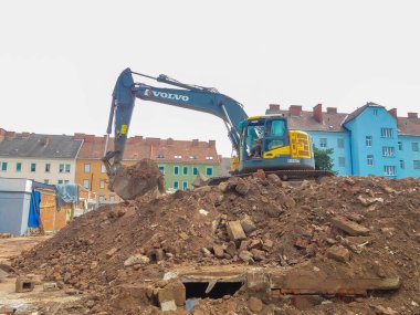 Graz, Avusturya-17.08.2020: Sarı endüstriyel kazıcı yıkım / inşaat sahasında çalışıyor.