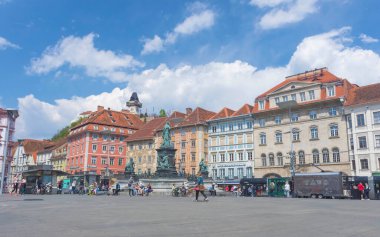 Graz, Avusturya-25 Nisan 2021: İnsanlar güzel Hauptplatz meydanında dinleniyor, Schlossberg tepesinde ünlü saat kulesi arka planda güneşli bir günde
