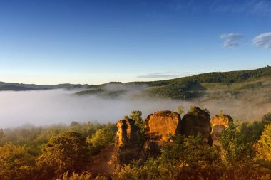 The rock towers of the Dragons Garden (Gradina Zmeilor ), a protected geological nature reserve in Salaj, Transylvania region, Romania, at sunrise, in summer foggy morning clipart