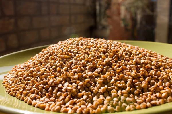 Buckwheat in a large green plate — Stock Photo, Image