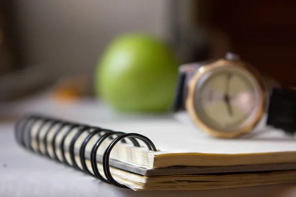 Notatnik i zegar na stole — Zdjęcie stockowe
