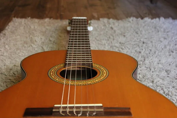 Acoustic guitar on the background of wood