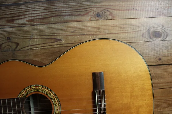 Acoustic guitar on the background of wood