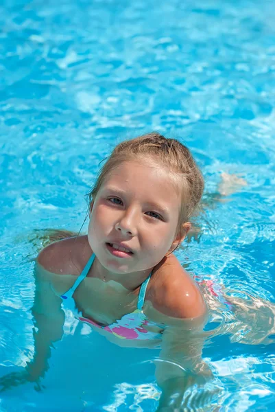 Fille assise sur le bord de la piscine — Photo