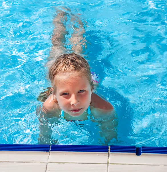 Chica sentada en el borde de la piscina — Foto de Stock