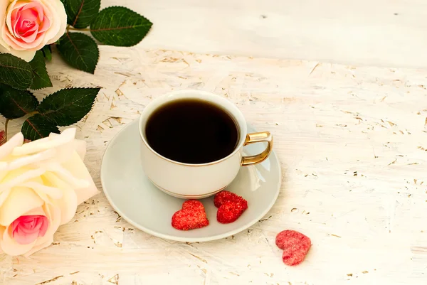 Tasse de café, coeurs de sucre et un bouquet de roses crème — Photo