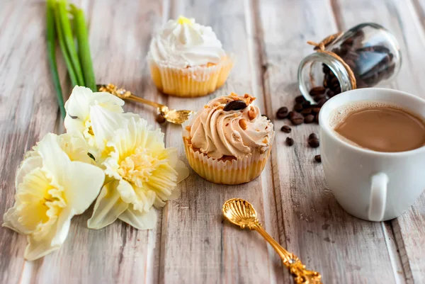 Gâteau et tasse de café et un bouquet de jonquilles — Photo