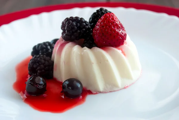 Vanilla panna cotta с ягодным соусом — стоковое фото