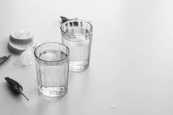 Vodka fria em um copo em uma mesa de madeira branca — Fotografia de Stock