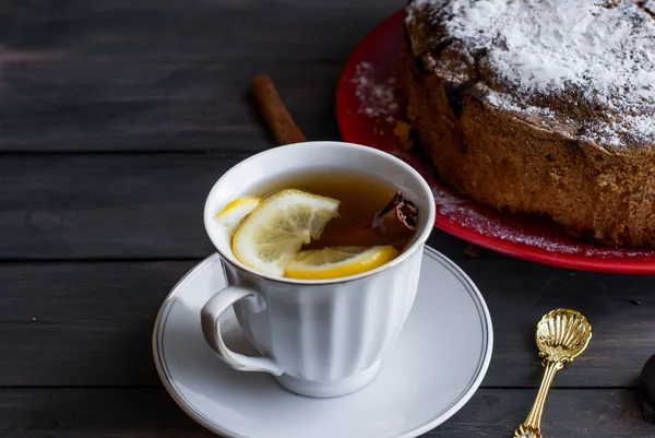 Кусок пирога с фруктами и чашкой чая с лимоном — стоковое фото