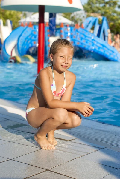 Fille près d'une attraction avec de l'eau dans un parc aquatique — Photo