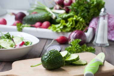 bir kesme tahtası üzerinde kıyılmış salatalık