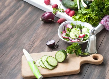 bir kesme tahtası üzerinde kıyılmış salatalık