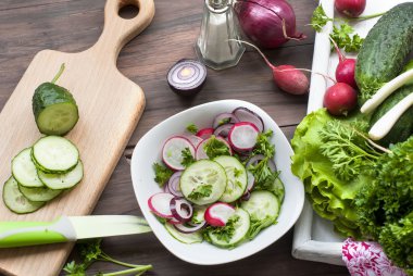 bir kesme tahtası üzerinde kıyılmış salatalık