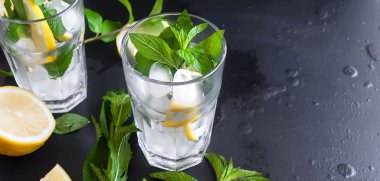 buz ve limon, nane ve buz üstünde siyah bir arka plan ile gözlük