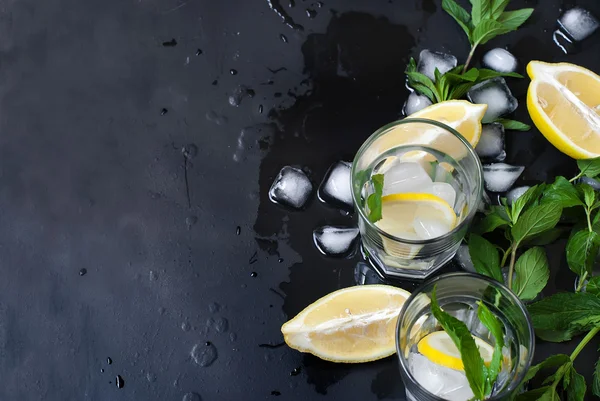 Glas med is och citron, mynta och is på en svart bakgrund — Stockfoto