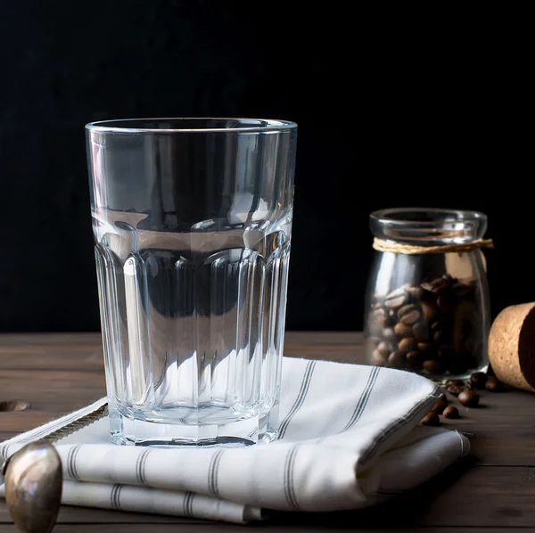 Esvaziar uma grande xícara de vidro de café na mesa de madeira, chave baixa — Fotografia de Stock